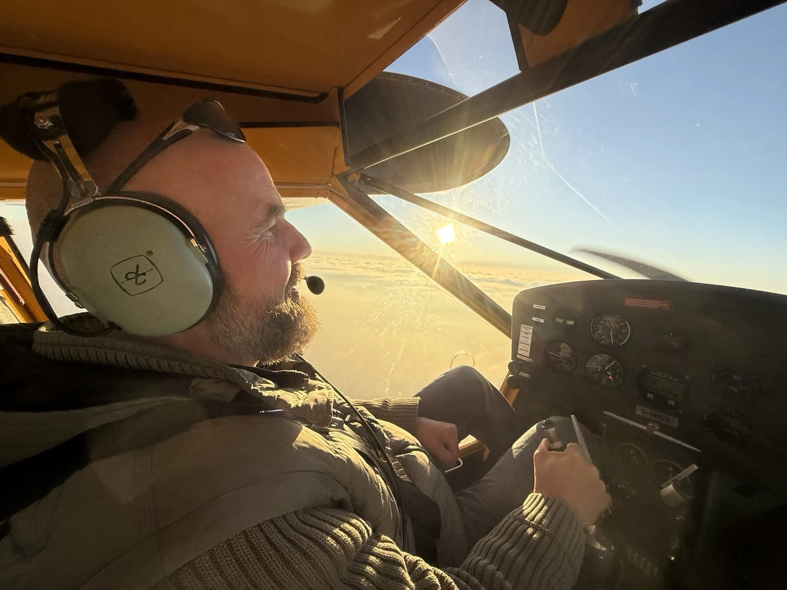 Frank allein mit Headset im Cockpit bei tiefem Sonnenlicht