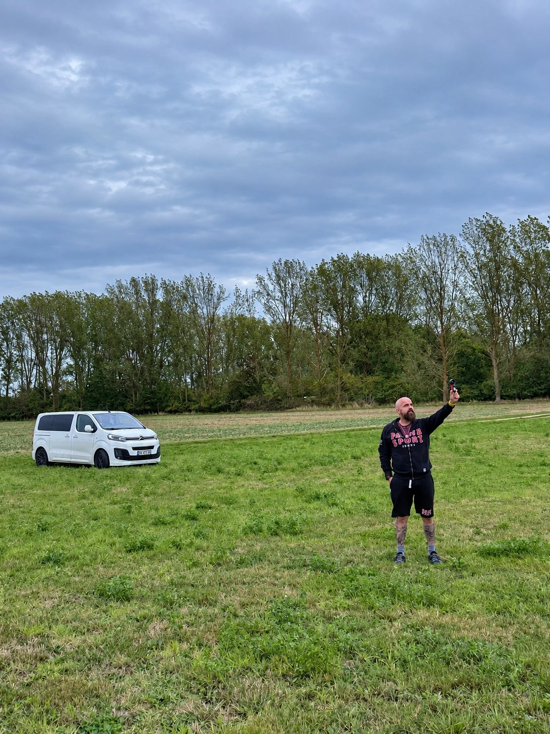 Frank misst die Böen auf der Wiese bei Pudagla, der weiße Transporter steht im Hintergrund.