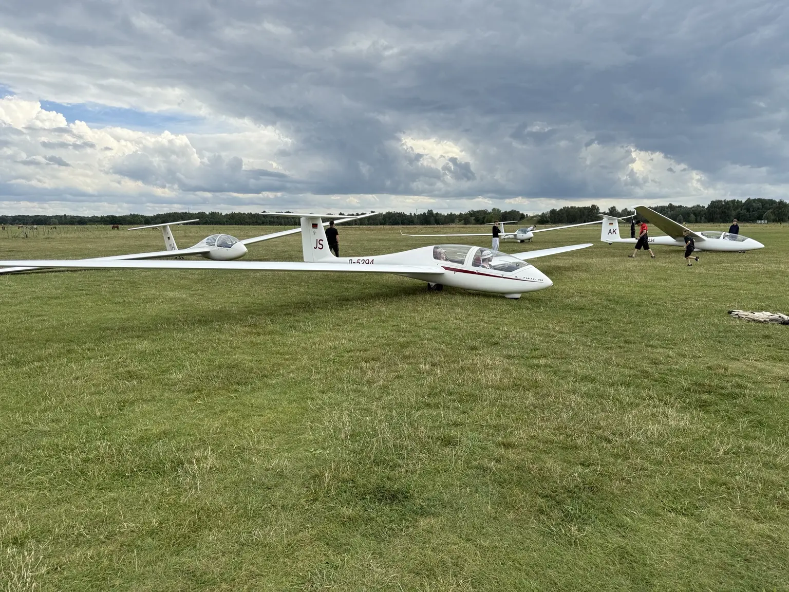 Mehrere Segelflugzeuge und Vereinsmitglieder auf dem Flugfeld in Neuruppin