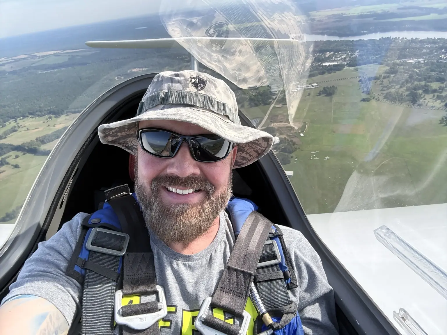Frank lächelnd im Cockpit eines Segelflugzeugs über der Landschaft bei Neuruppin